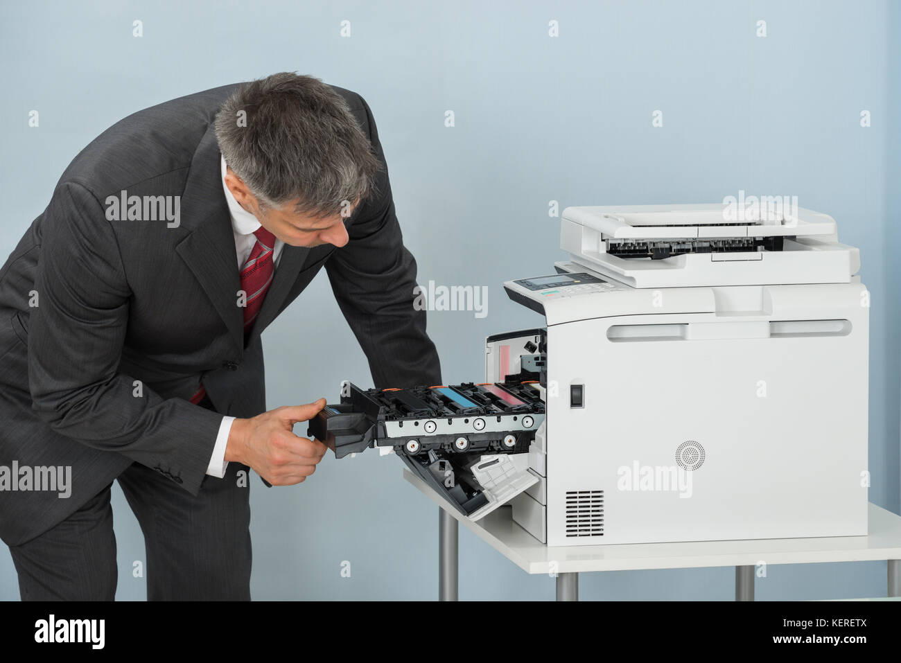 Reifen Geschäftsmann zur Festsetzung der Patrone im Drucker Maschine im Büro Stockfoto