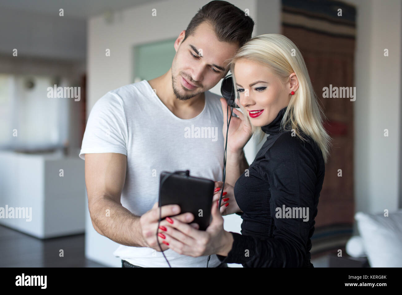 Junge kaukasier Paar Musik hören zu Hause, Mann teilen Kopfhörer mit Frau Stockfoto
