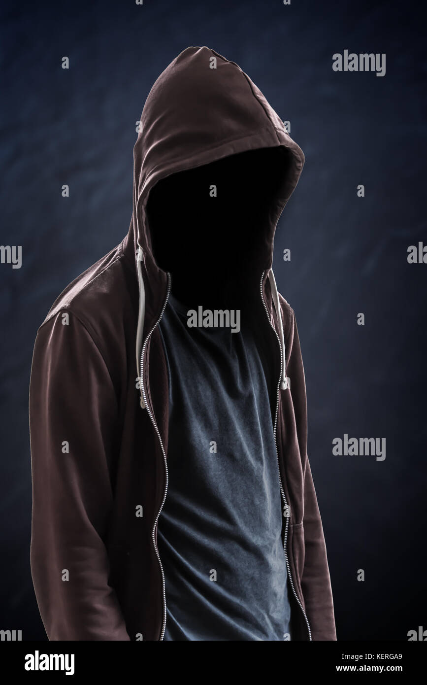 Silhouette eines Mannes mit Kapuze und Gesicht im Dunkeln, schwarzer Hintergrund mit Kopierraum, kriminellem oder Hackerkonzept Stockfoto