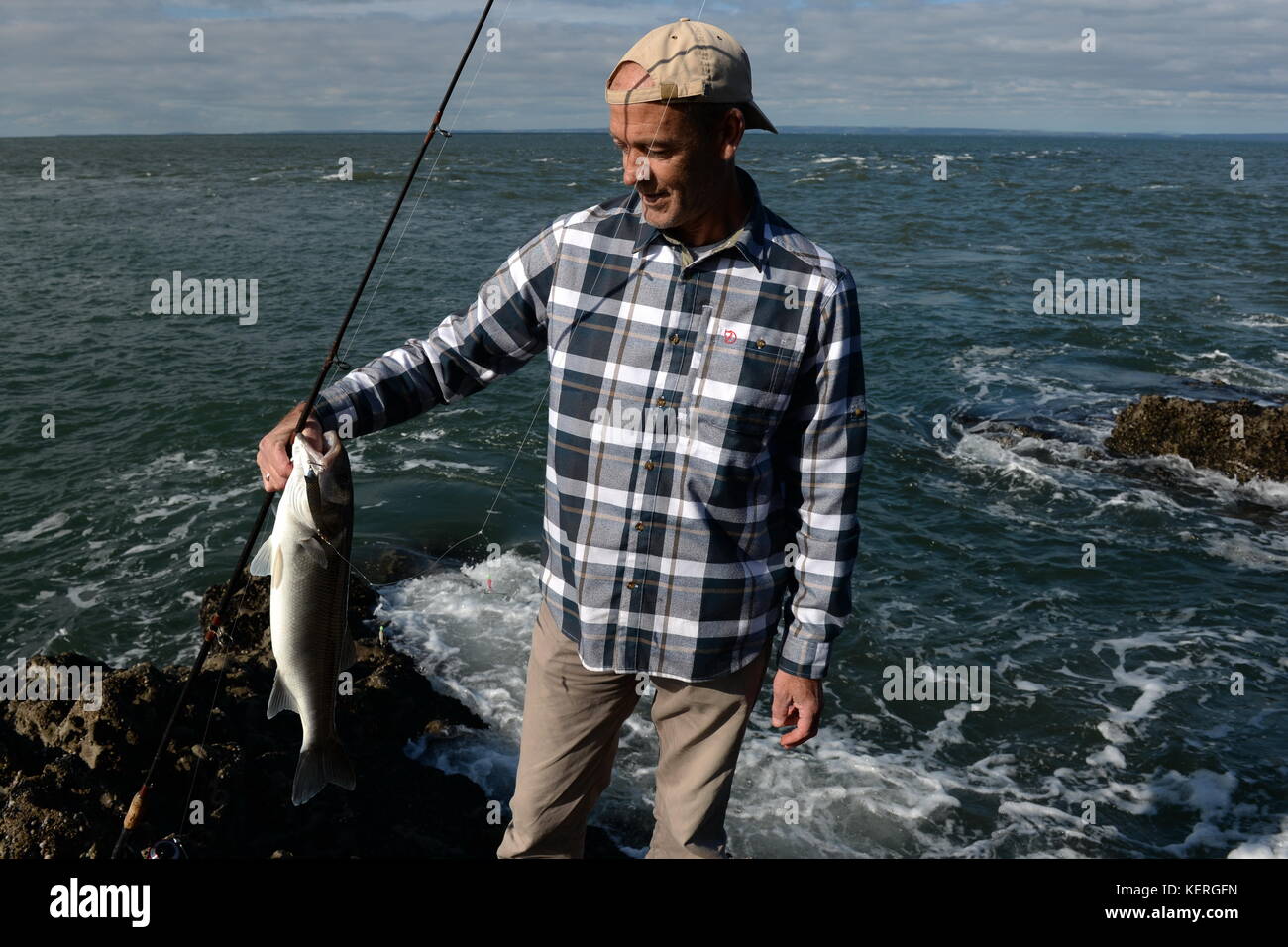 Seebarsch Fischer mit der Stange und Haken Stockfoto