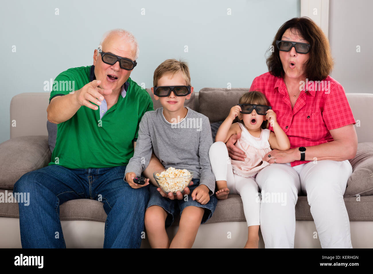 Großeltern unterhalten die Wiedergabe von 3D-TV zu Hause mit Kindern Stockfoto