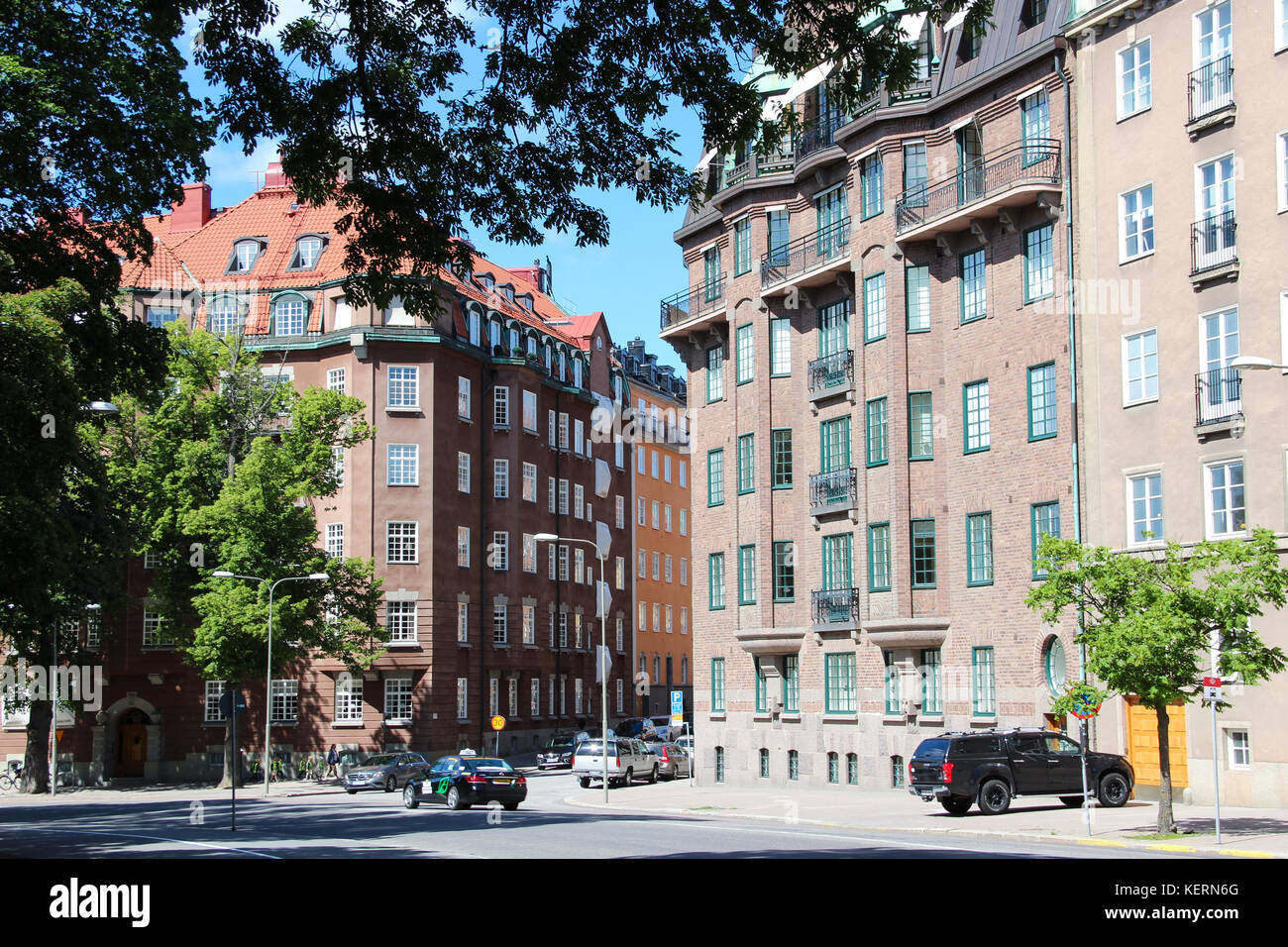 Blick auf die Straße mit einem klassischen schwedischen Häuser, skandinavischen Stil mit braunen Ziegel und grauem Stein, die Autos auf der Straße geparkt werden, das Stadtzentrum Stockfoto