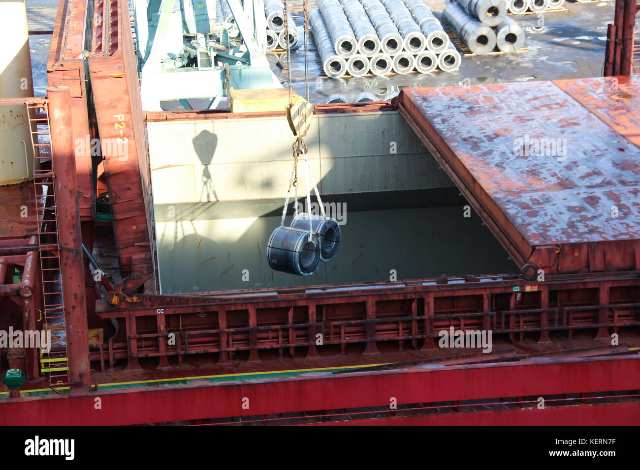 Laden riesige Aluminium Spulen als Rohstoffe für die Schwerindustrie, Instrumentierung und Engineering zu halten auf dem Handel Schiff mit einem Kran Stockfoto