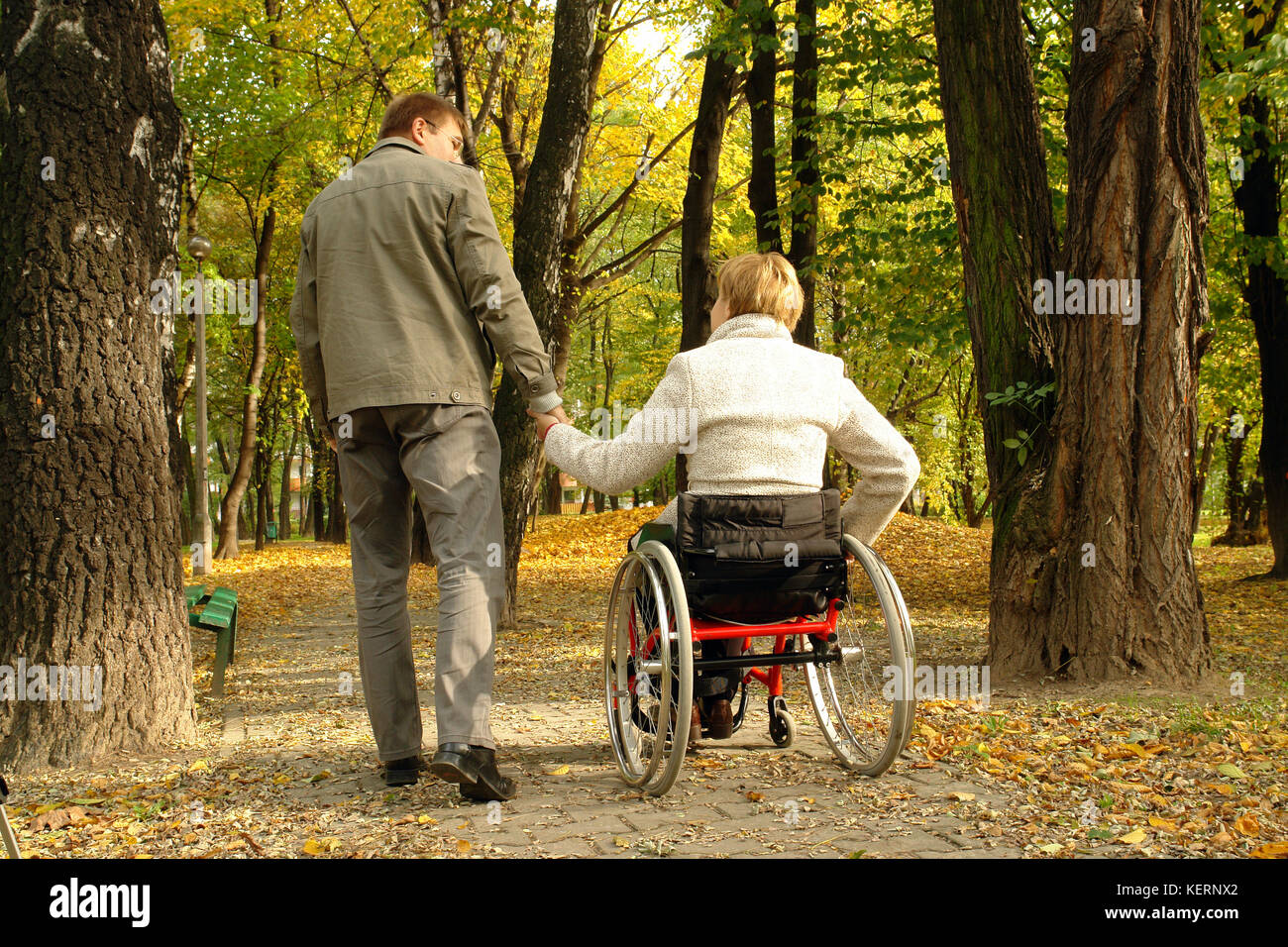 Mann und behinderte Frau, Spaziergang im Park Alley im Herbst Zeit Stockfoto
