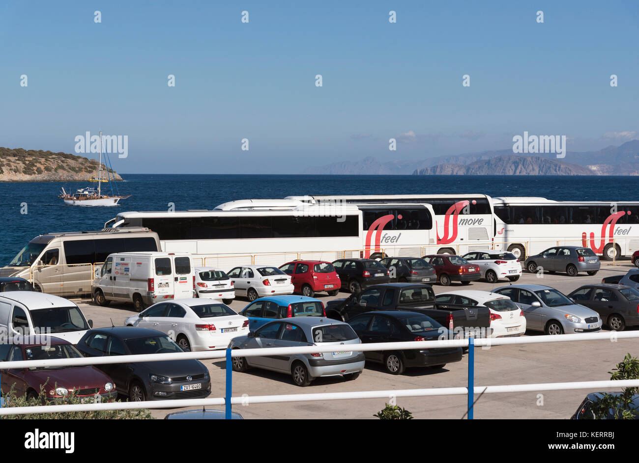Agios Nikolaos, Kreta, Griechenland. Bus- und reisebus-Park an der Hafenfront. Blick auf das Meer und die Berge Stockfoto