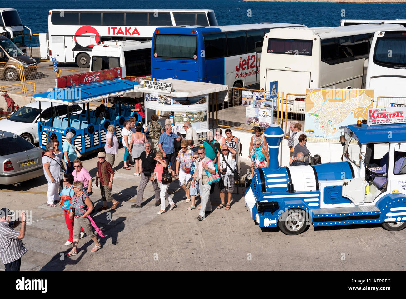 Agios Nikolaos, Kreta, Griechenland. Bus- und reisebus-Park an der Hafenfront. Touristen, die mit ihren Reisebussen im Hafengebiet ankommen Stockfoto
