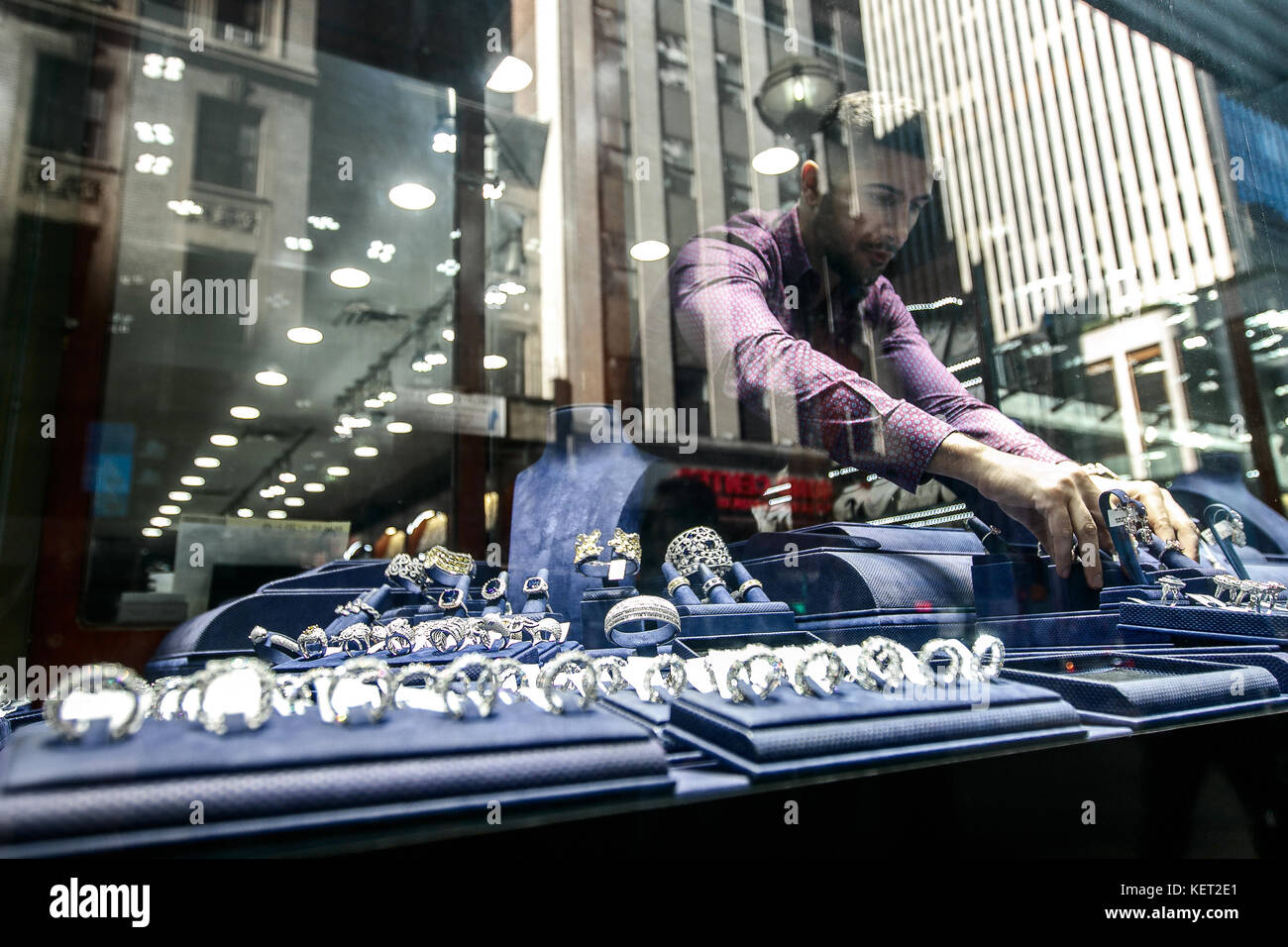 Ein Juweliergeschäft Mitarbeiter ist die Einrichtung des vorderen Fensters speichern, bevor Sie den Store für den Tag wird geöffnet. Diamond District von New York City. Stockfoto