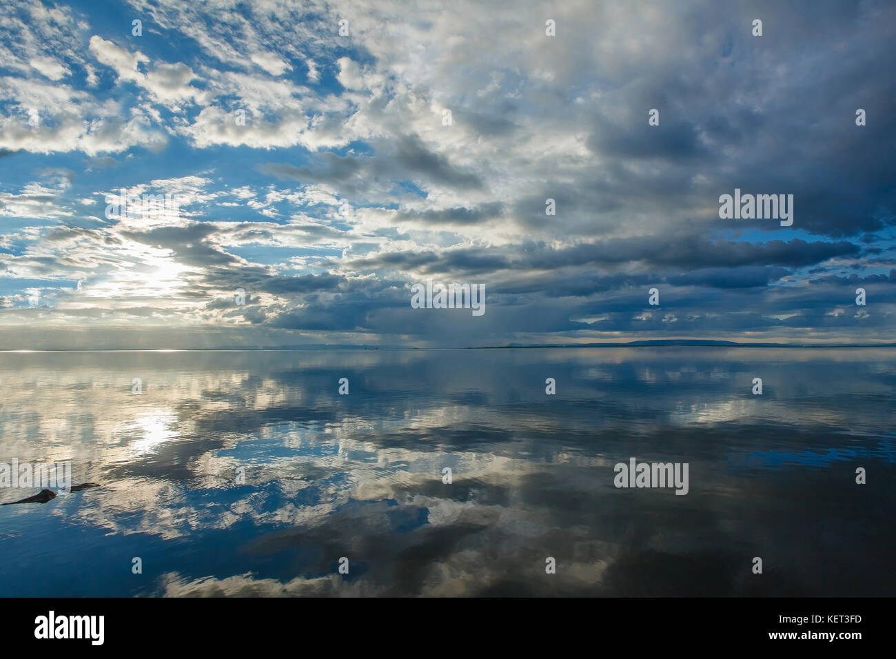 Blast in den Abendhimmel reflektiert mit einer großen Oberfläche.der Sonnenuntergang spiegelt sich wunderschön auf der Oberfläche des Wassers. In der Monsunzeit Stockfoto