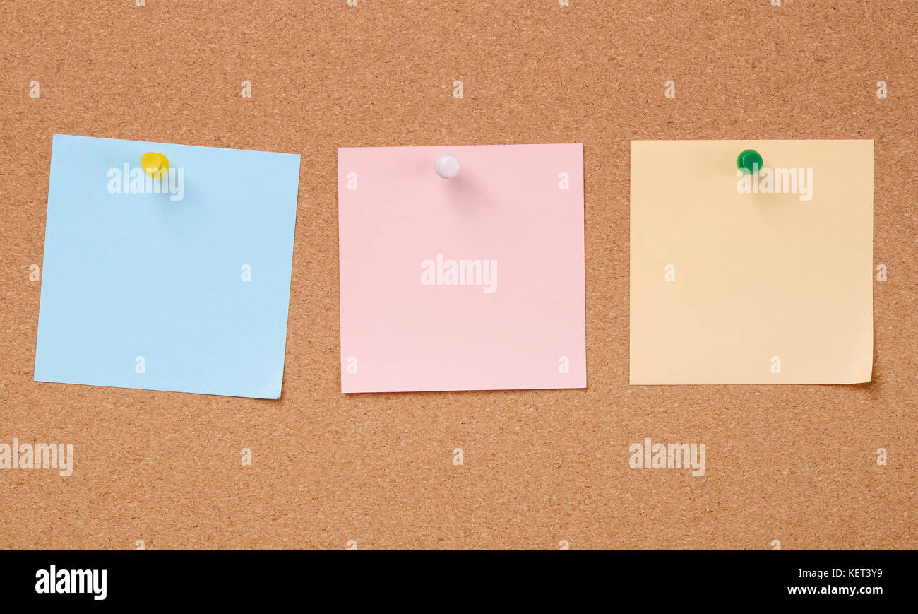Reihe von drei Farben Papier Notizen auf Cork board Stockfoto