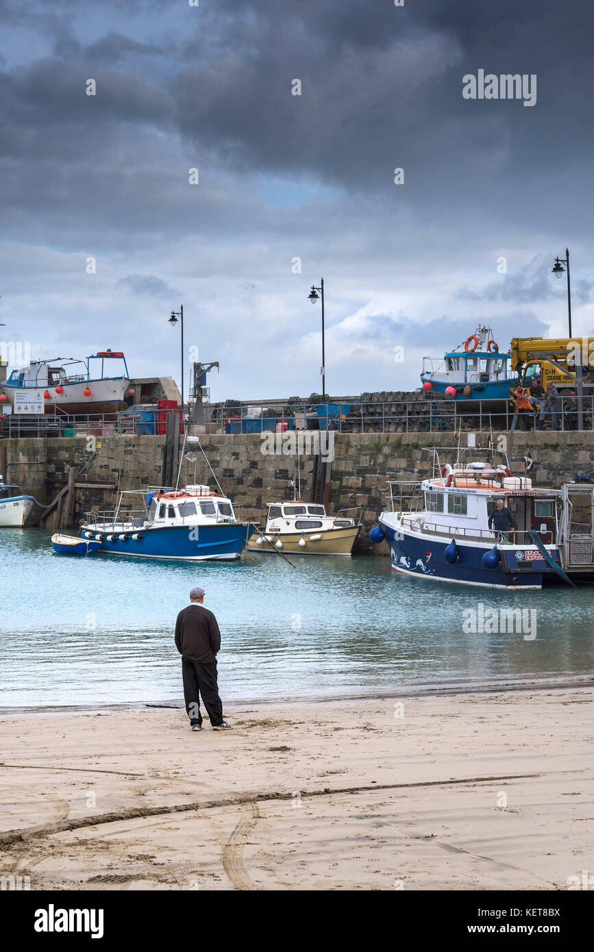 Newquay Harbour Cornwall - ein Mann, der am Ufer in Newquay Harbour steht. Stockfoto