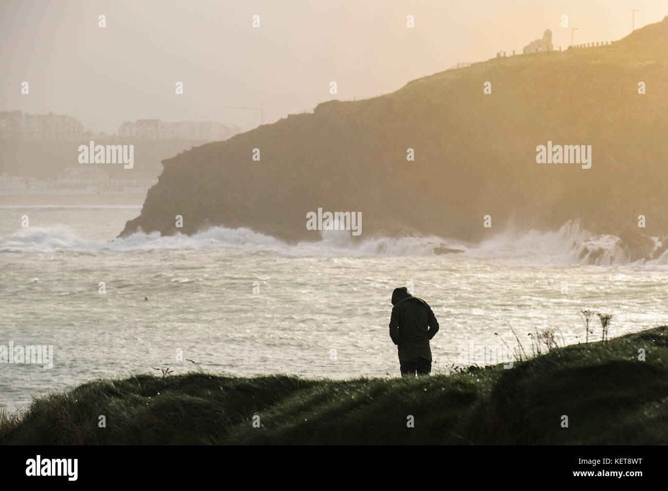 UK Weather - die Silhouette einer Person, die an der Küste bei rauem Wetter steht. Stockfoto