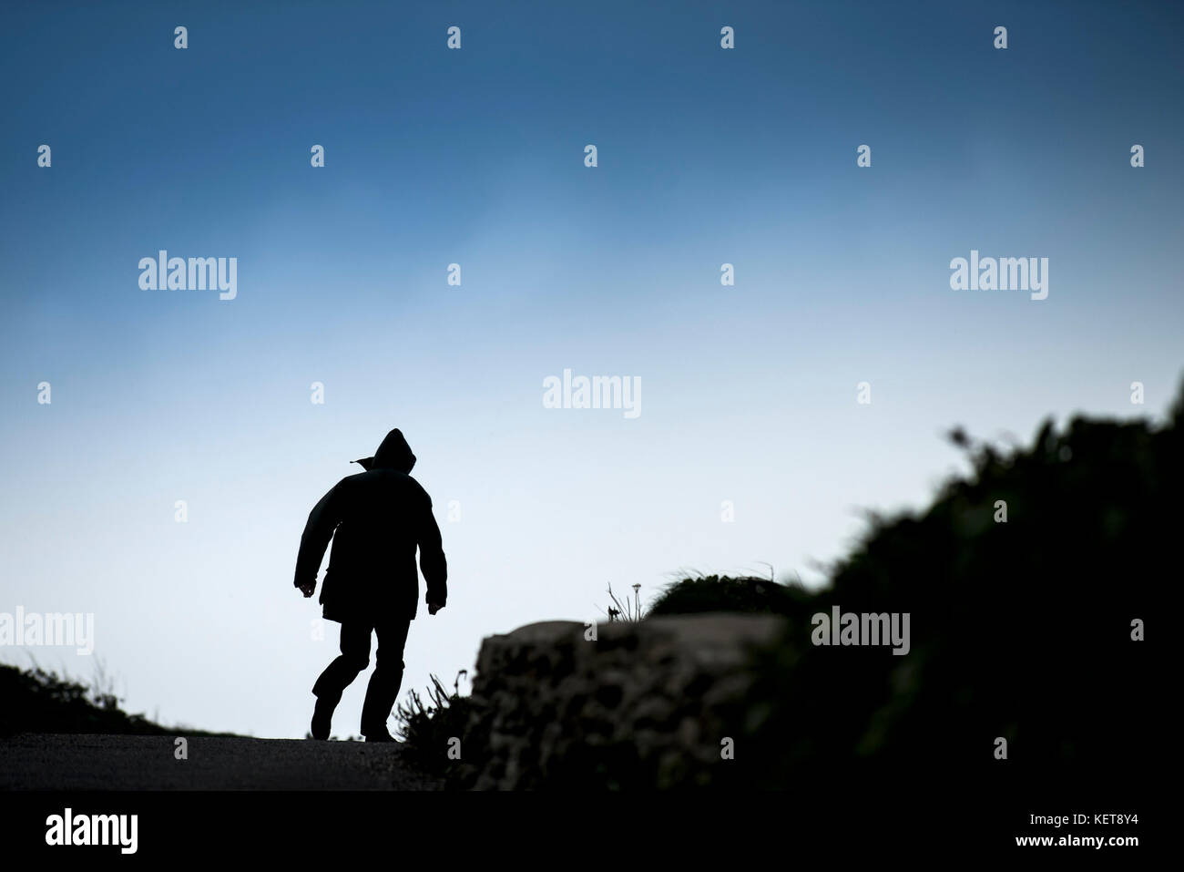 Die Silhouette eines Menschen auf dem Weg ins Licht. Stockfoto