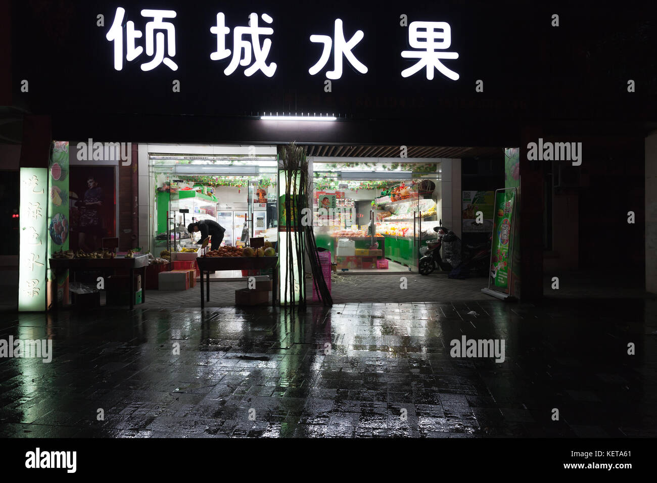 Hangzhou, China - Dezember 3, 2014: Traditionelle chinesische kleinen Lebensmittelmarkt mit Gemüse und Neon Werbung auf der Wand. Nacht street view Stockfoto