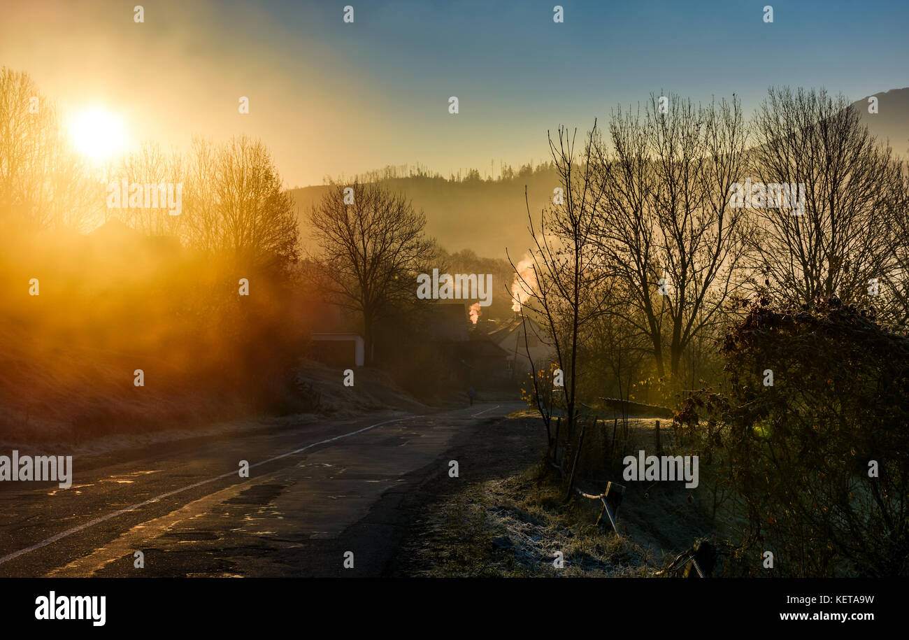 Straße durch Bergdorf in Nebel Sonnenaufgang. schöne Landschaft im Herbst Stockfoto