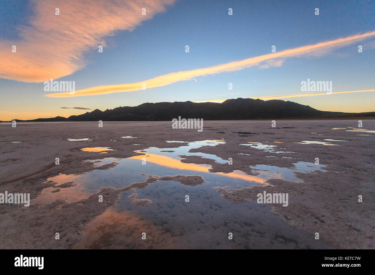 Rosa Wolken bei Sonnenuntergang spiegeln sich auf der Salzkruste des Salar de Uyuni South Lipez Bolivia South America Stockfoto