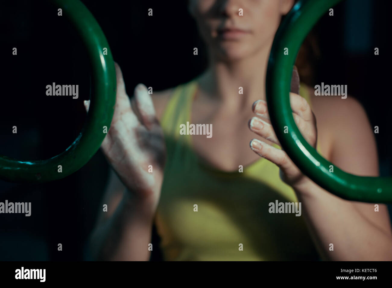 Ein Mädchen reibt ihre Hände mit Kreide vor dem Training Stockfoto