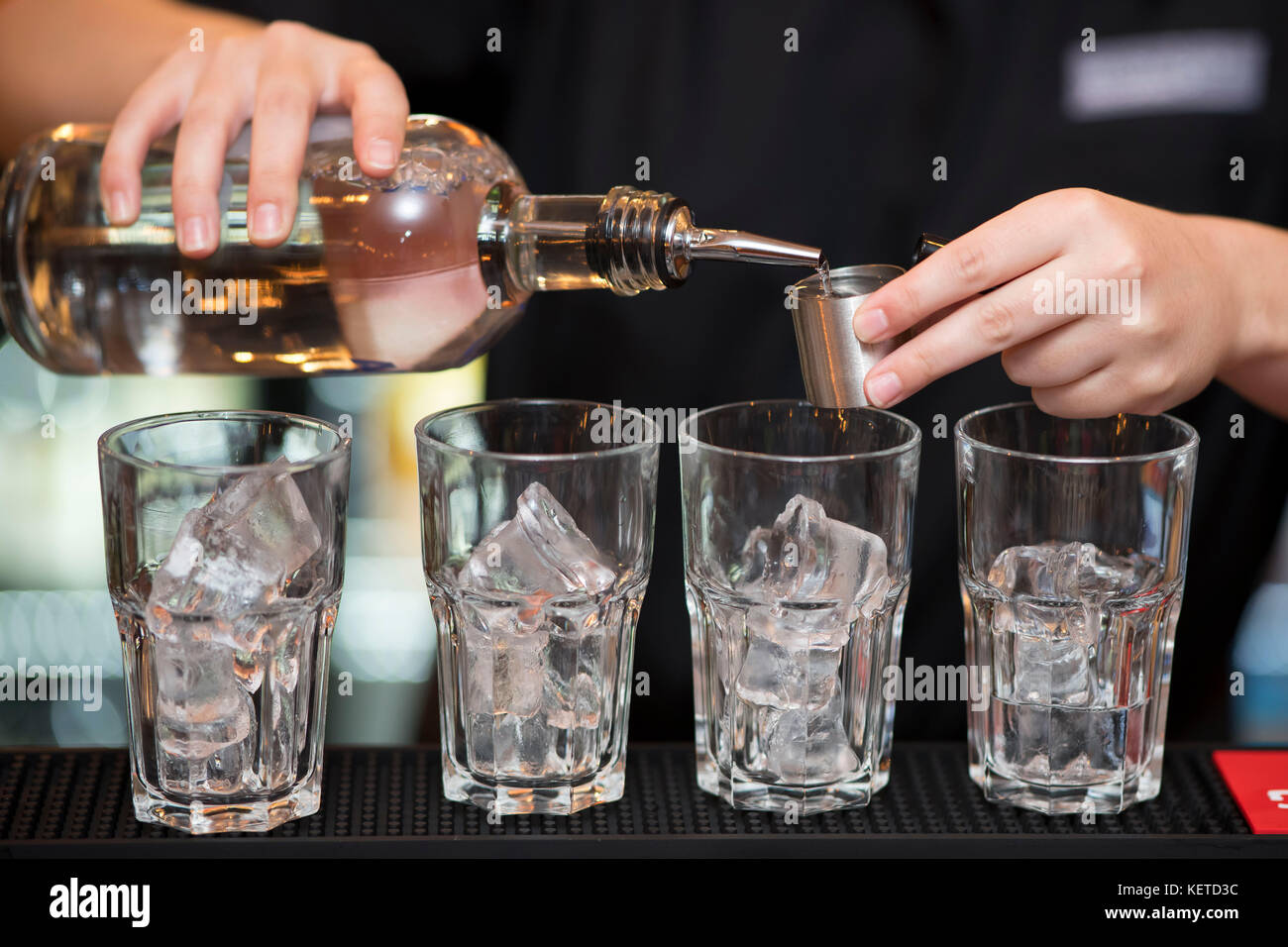 Ein Barkeeper/bar Arbeiter gießt Aufnahmen von Spirituosen in einer Bar Pub. Stockfoto