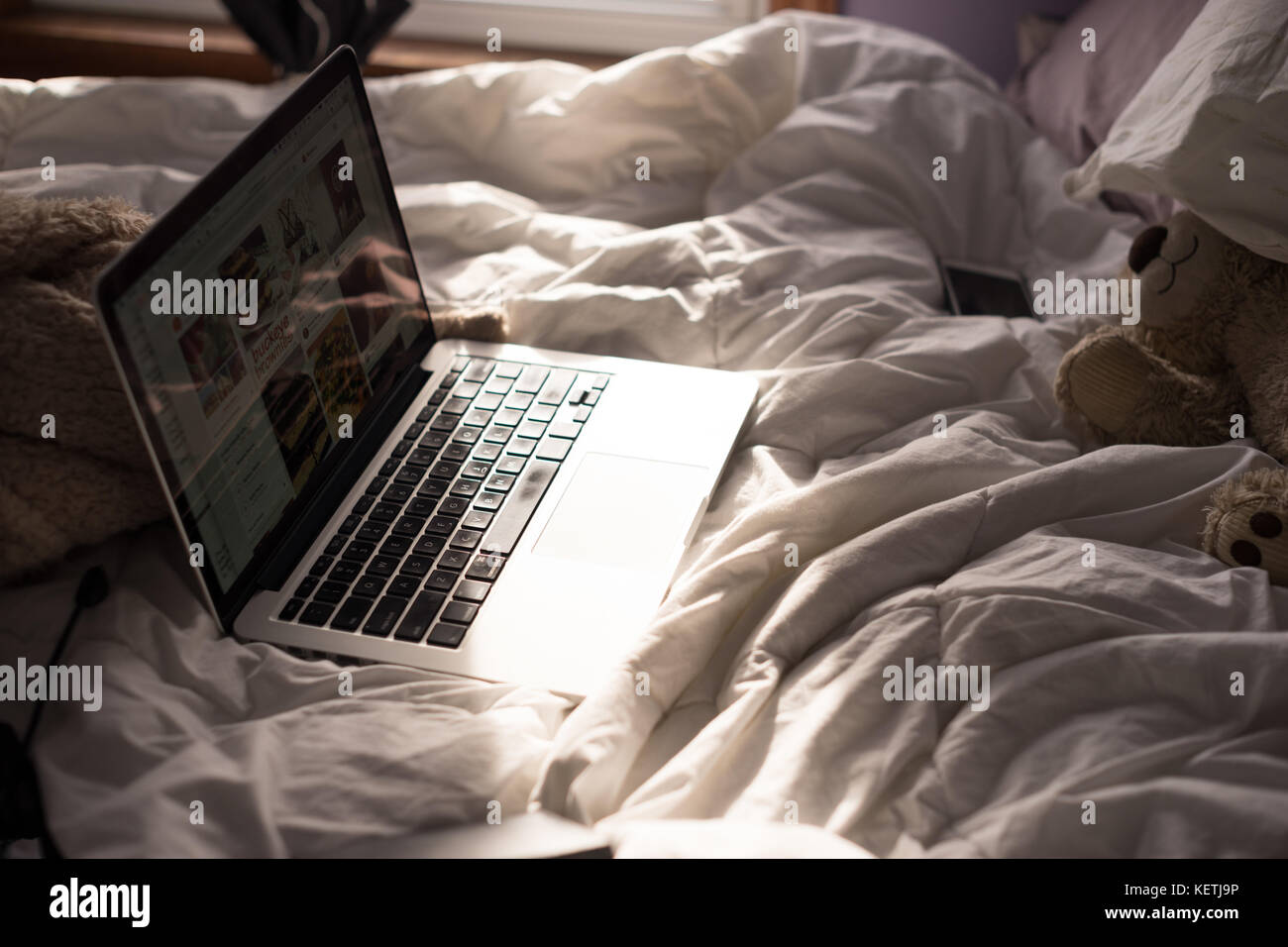 Warmes sonniges, komfortables Bett auf einem kalten Wintertag Stockfoto