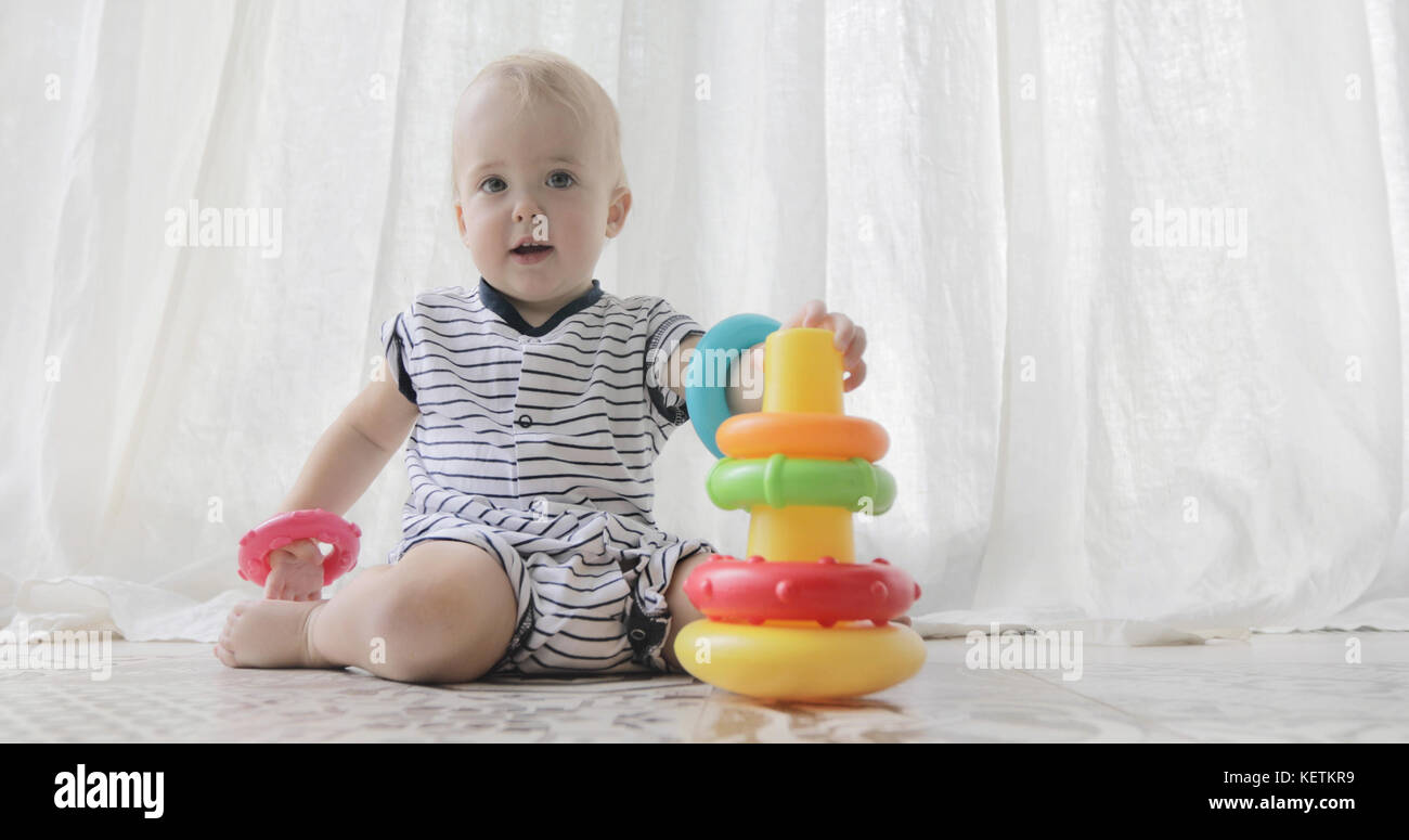 Adorable Baby mit Spielzeug spielen auf weißem Hintergrund Stockfoto