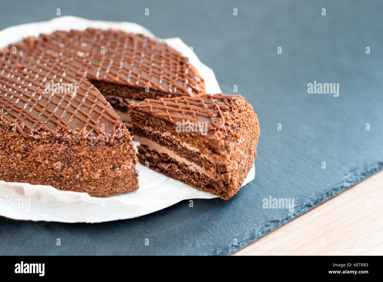 In Scheiben geschnitten leckere Schokoladenkuchen auf schiefer Tisch. Stoppen Sie die Diät Konzept, Ziel und Ende für gesundes Essen. Stockfoto