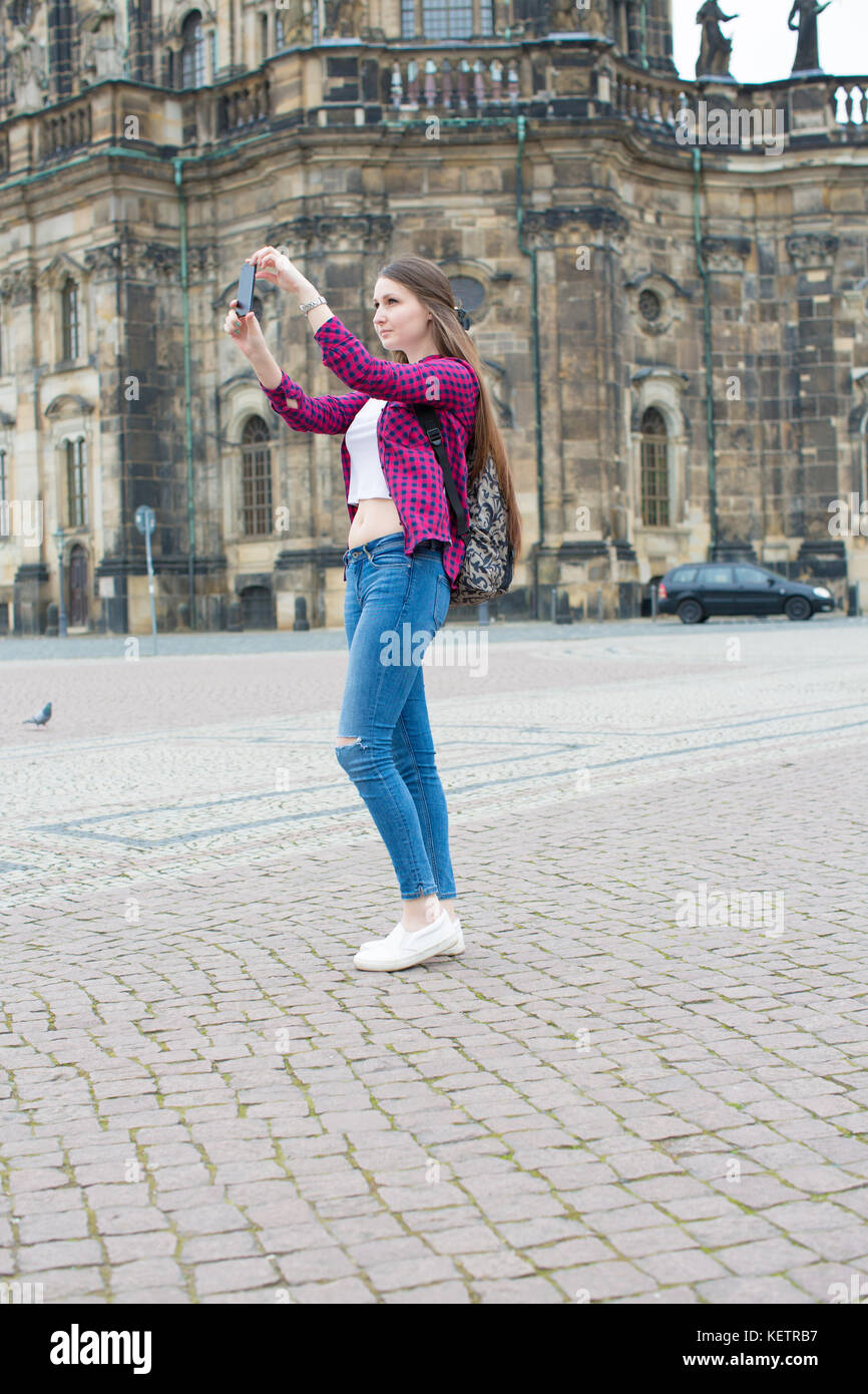 Junge Frau mit langem Haar Smartphone in der Europäischen Altstadt Stockfoto