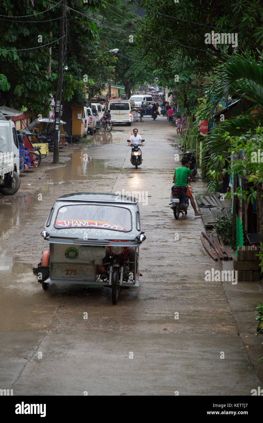 Motorisierte dreiräder (Auto-rikscha) bei nassen Straßen von El Nido, Palawan Stockfoto