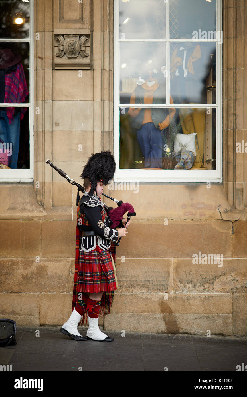 Street performance Gaukler, Touristen, Edinburgh, Schottland, die Royal Mile Canongate traditionell gekleidet Piper spielen seiner Bagpipes für Geld Stockfoto