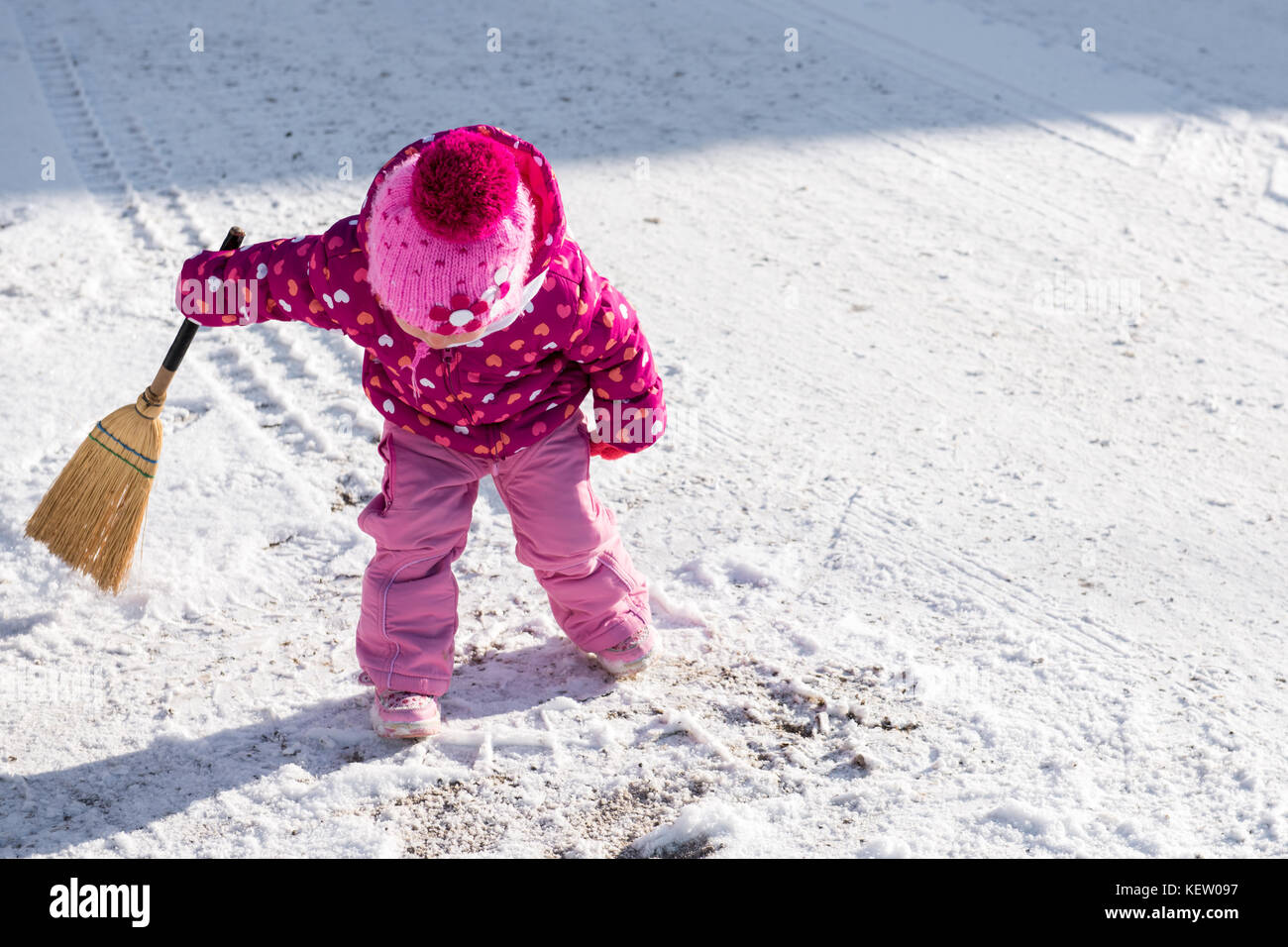 Süße kleine Mädchen spielen mit einem Besen außerhalb während der schneereichen Winter Tag Stockfoto