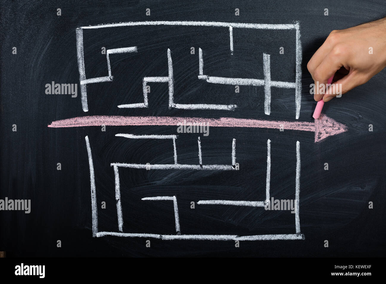 Nahaufnahme der Person Zeichnen von geraden rote Linie über Labyrinth auf der Tafel Stockfoto