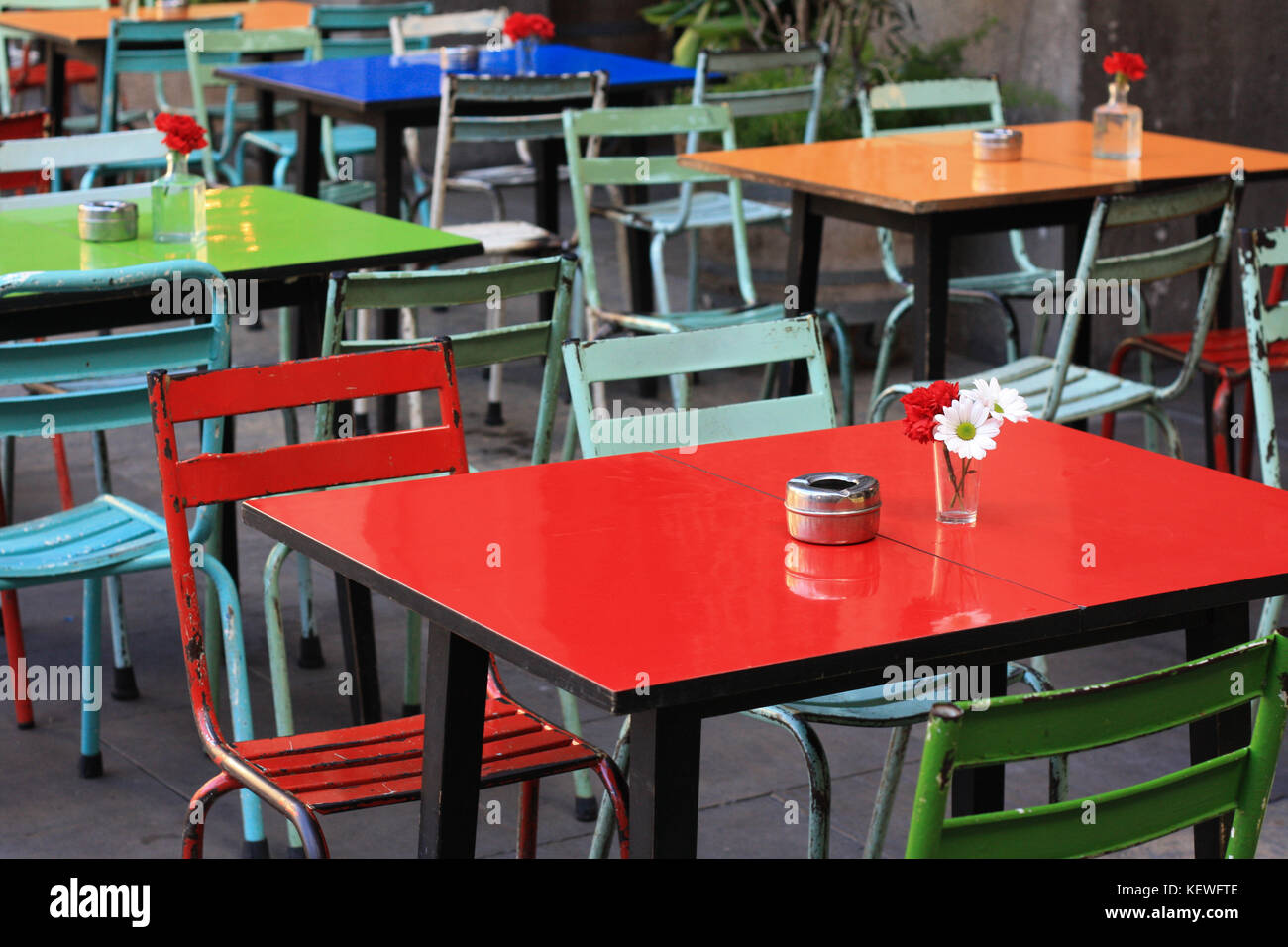 Farbenfrohe Tische und Stühle in einem Café im Freien in Placa Reial, Barcelona, Spanien. Stockfoto