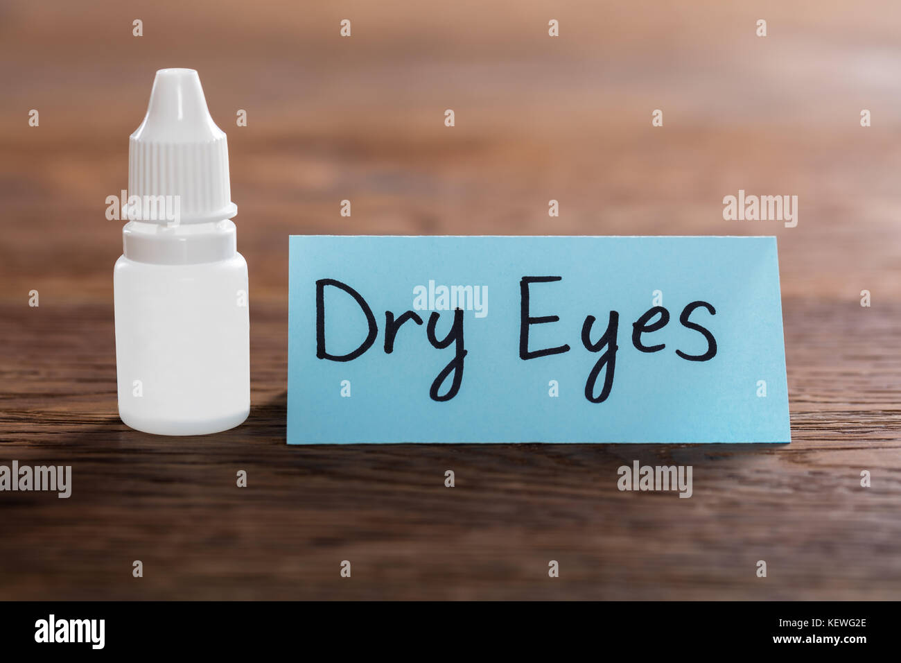Trockene Augen Konzept mit Augentropfen auf hölzernen Schreibtisch Stockfoto