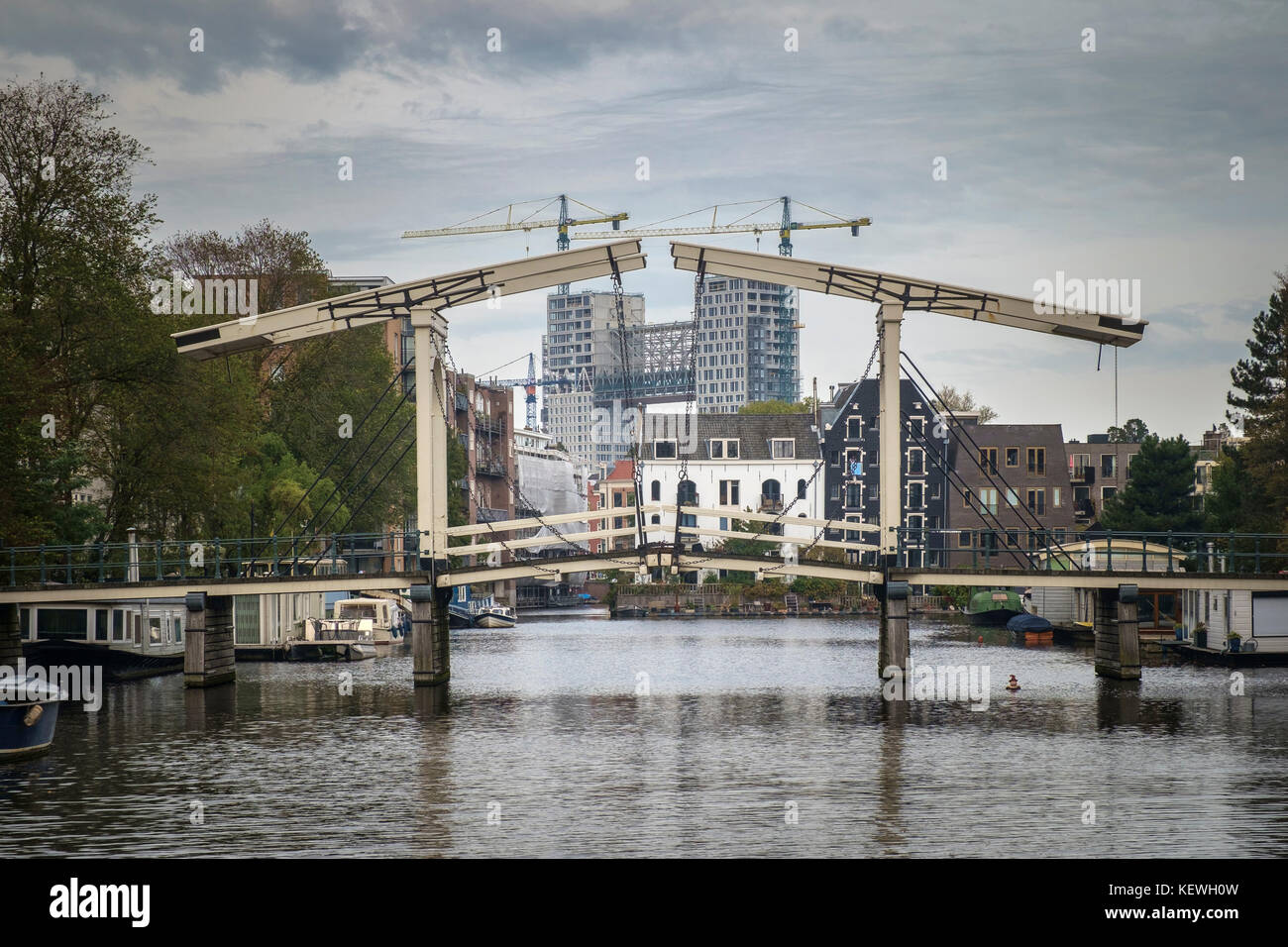 Alte hölzerne Zugbrücke frames neue Hochhaus appartment Komplexe in Amsterdam. Stockfoto