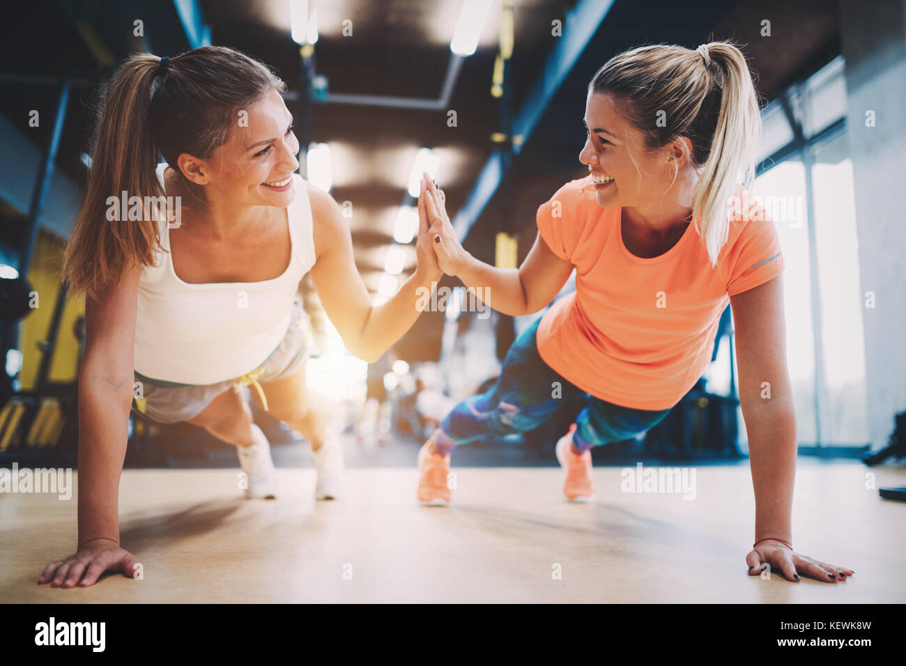 Zwei sportliche Mädchen, die Push-ups in der Turnhalle Stockfoto