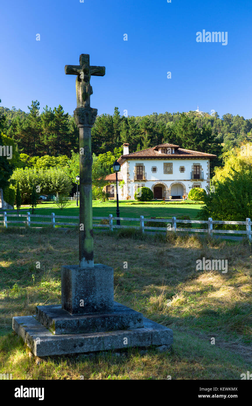 Christian Kreuz Jesu Christi mit stilvollen Hacienda Haus hinter in Liendo, Kantabrien, Spanien Stockfoto