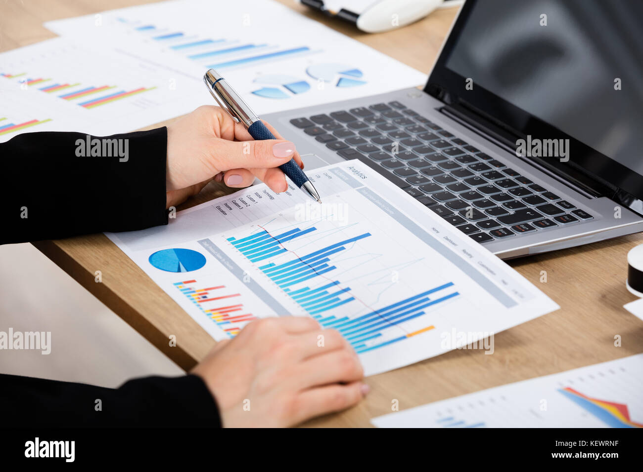 Nahaufnahme Einer Geschäftsfrau, die Graph mit Laptop auf dem Holztisch analysiert Stockfoto