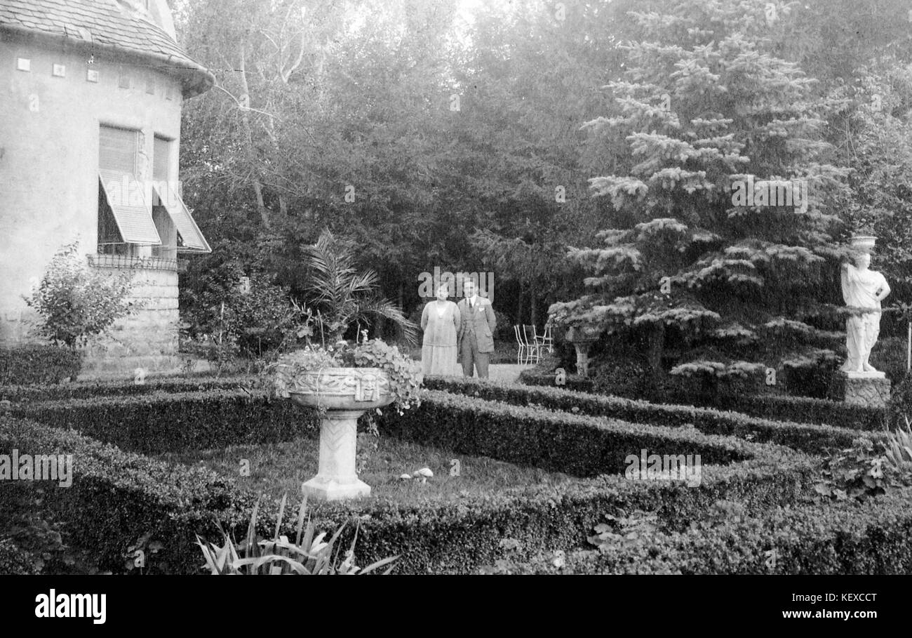 Ein Doppelporträt eines Mannes und einer Frau in einem Garten im Sommer, mit einer Skulptur im Hintergrund. Das Foto mit der Bezeichnung Fortepan 2926 fängt wahrscheinlich einen persönlichen Moment in einer ruhigen Gartenumgebung ein. Stockfoto