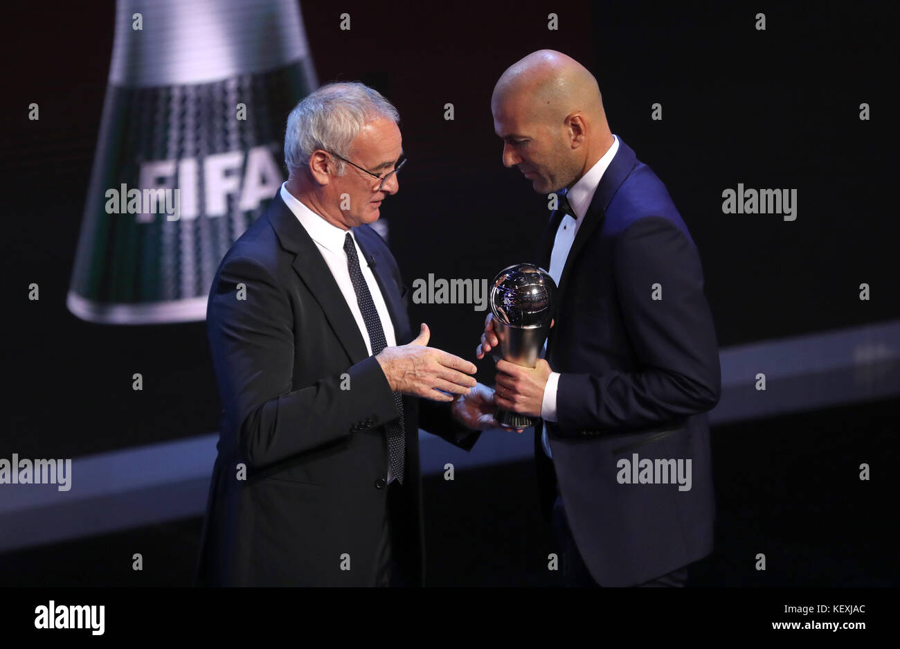 Zinedine Zidane nimmt die Auszeichnung für den FIFA Männer-Coach des Jahres von Claudio Ranieri während der besten FIFA Football Awards 2017 im Palladium Theatre, London, entgegen. Stockfoto