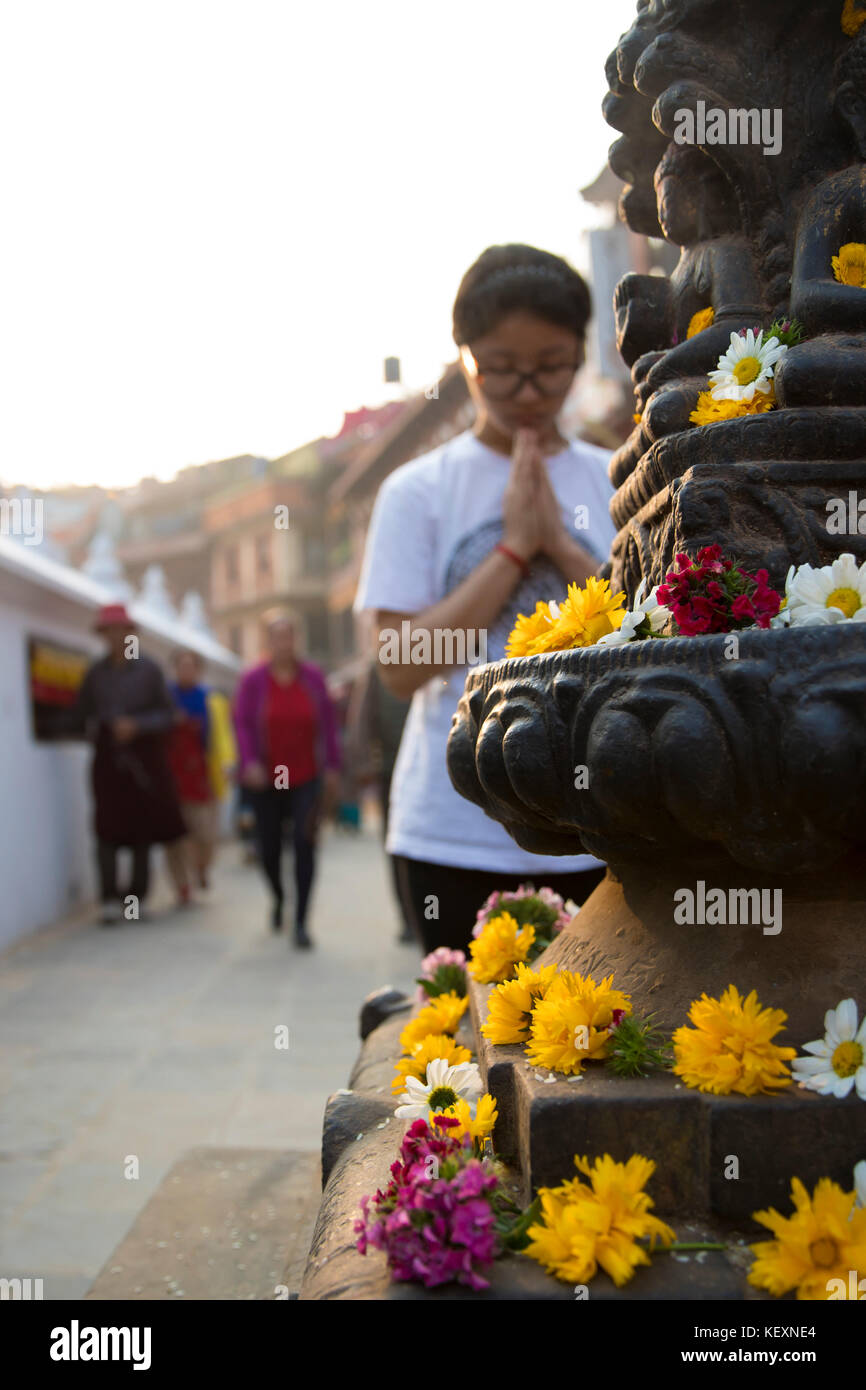 Foto einer Frau, die an der Statue im Boudhanath Tempel, Kathmandu, Nepal betet Stockfoto