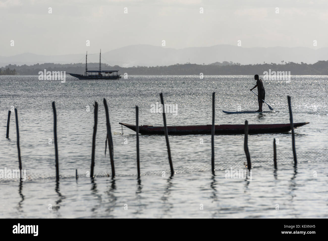 Mann, der bei Sonnenuntergang im tropischen Süden Bahia, Halbinsel Marau, Brasilien, auf seinem Stand-up-Paddle-Board reitet Stockfoto