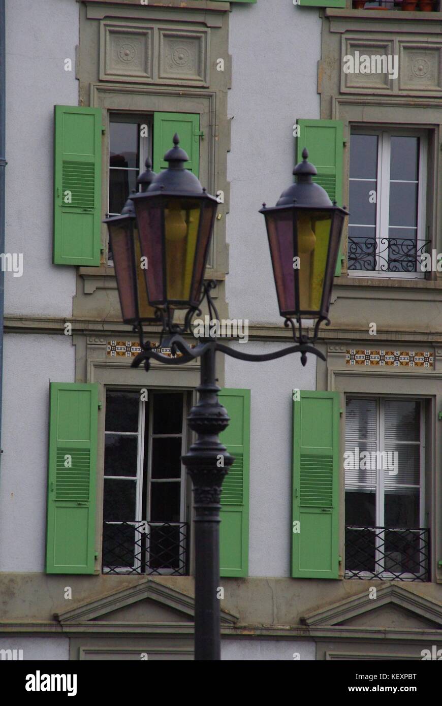 Grünen Fensterläden Fenster und eine alte Straßenlaterne in Lausanne, Schweiz Stockfoto