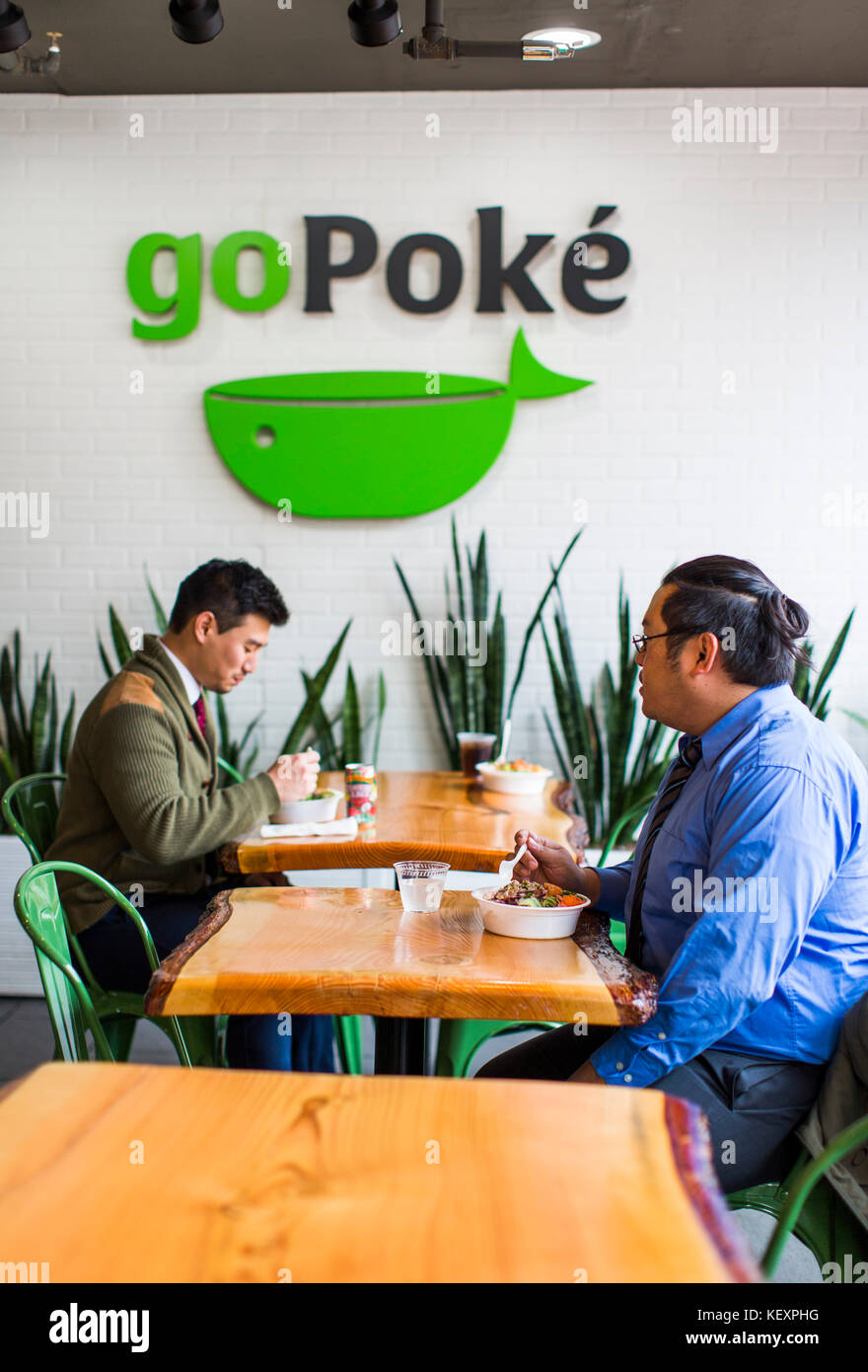 Foto von zwei männlichen Kunden im Restaurant Essen Poke, traditionelle hawaiianische Gericht, Seattle, Washington State, USA Stockfoto