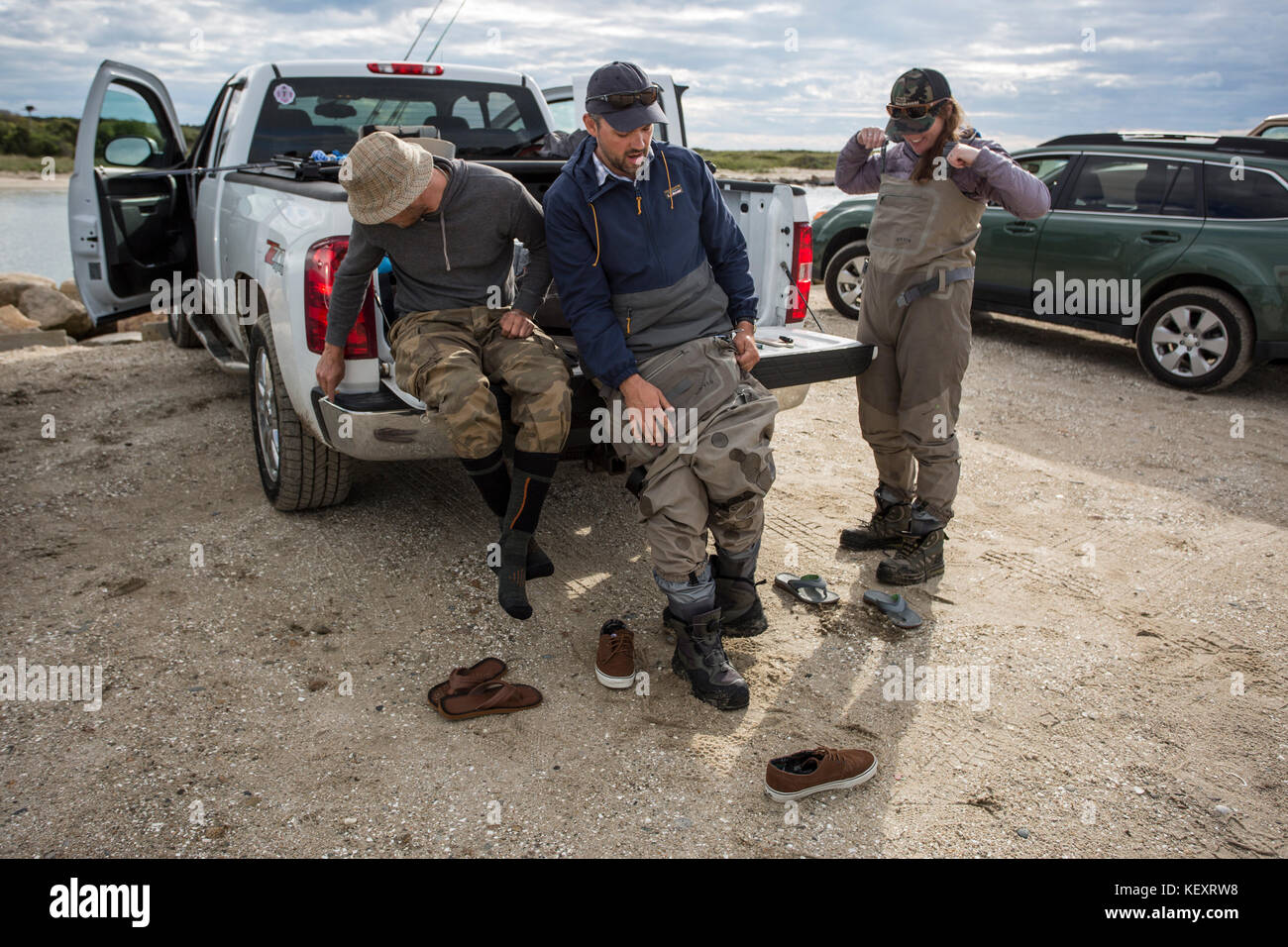 Zwei Männer und eine Frau auf das Waten Stiefel neben parkenden Autos, Massachusetts, USA Stockfoto