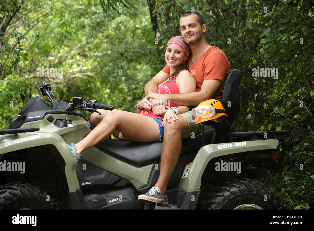 Paar lächelnd und umarmt, während auf dem Quad in Emotionen Native Park, Quintana Roo, Mexiko sitzen Stockfoto