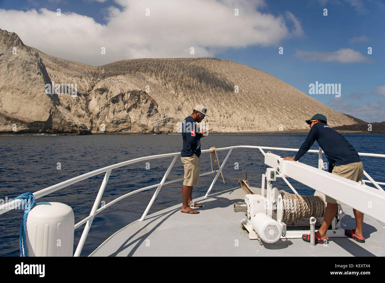 Foto von zwei männlichen Seeleuten am Bug des Schiffes, das auf der Insel San Benedicto, Revillagigedo Islands, Colima, Mexiko ankommt Stockfoto