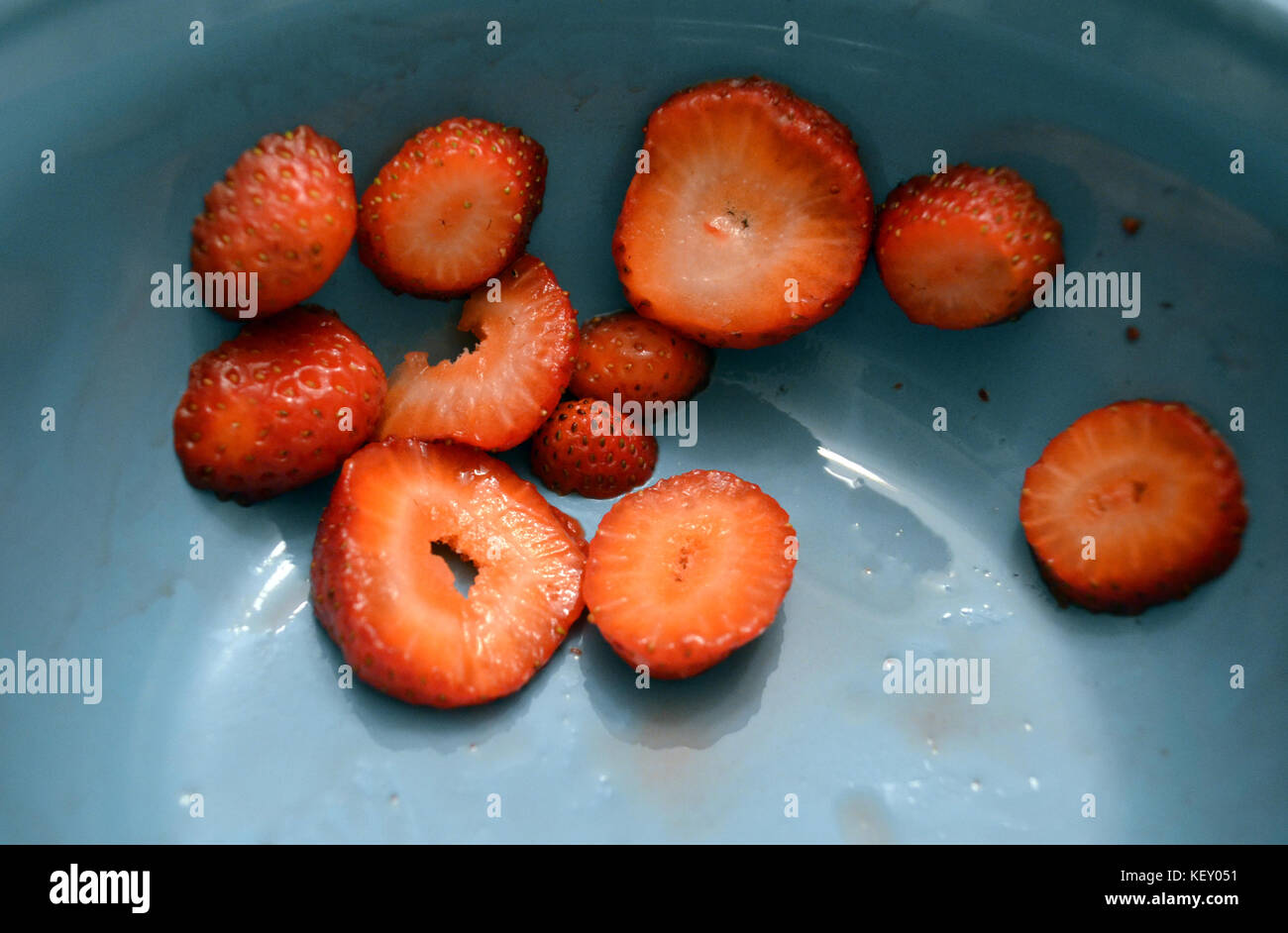 In Scheiben geschnittene Erdbeeren in eine blaue Schüssel. Stockfoto