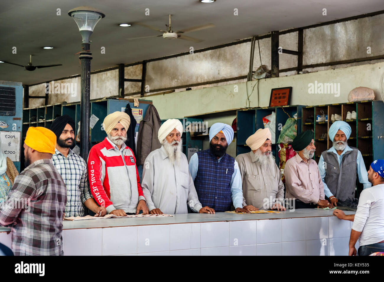 Lokale Sikhs, Männer an der Schuhkollektion Kiosk, goldenen Tempel von Amritsar, dem heiligsten Gurdwara und Wallfahrtsort des Sikhismus, Amritsar, Punjab, Indien Stockfoto