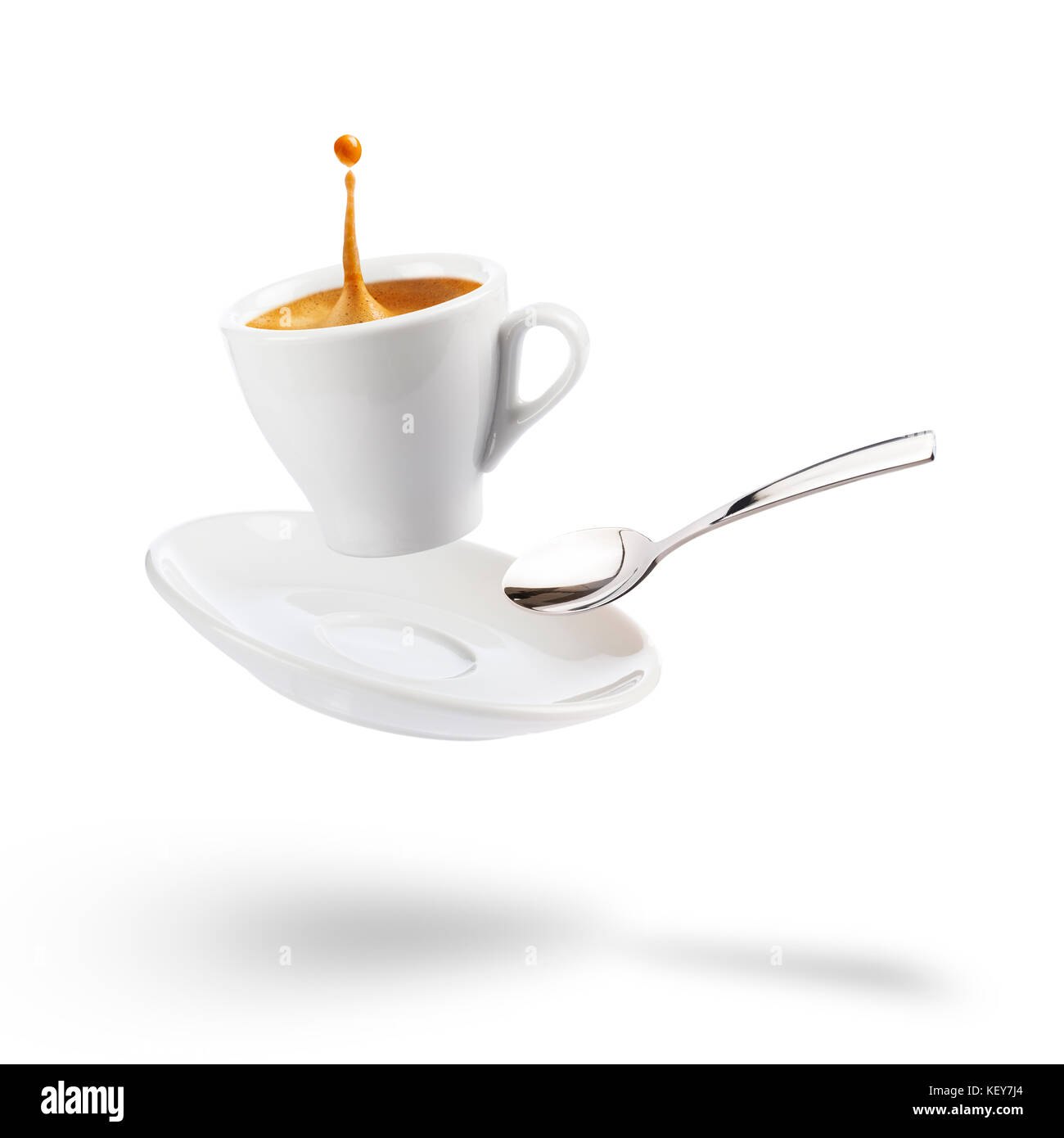 Tasse Kaffee mit Untertasse und Löffel floating auf weißem Hintergrund mit Schatten Stockfoto
