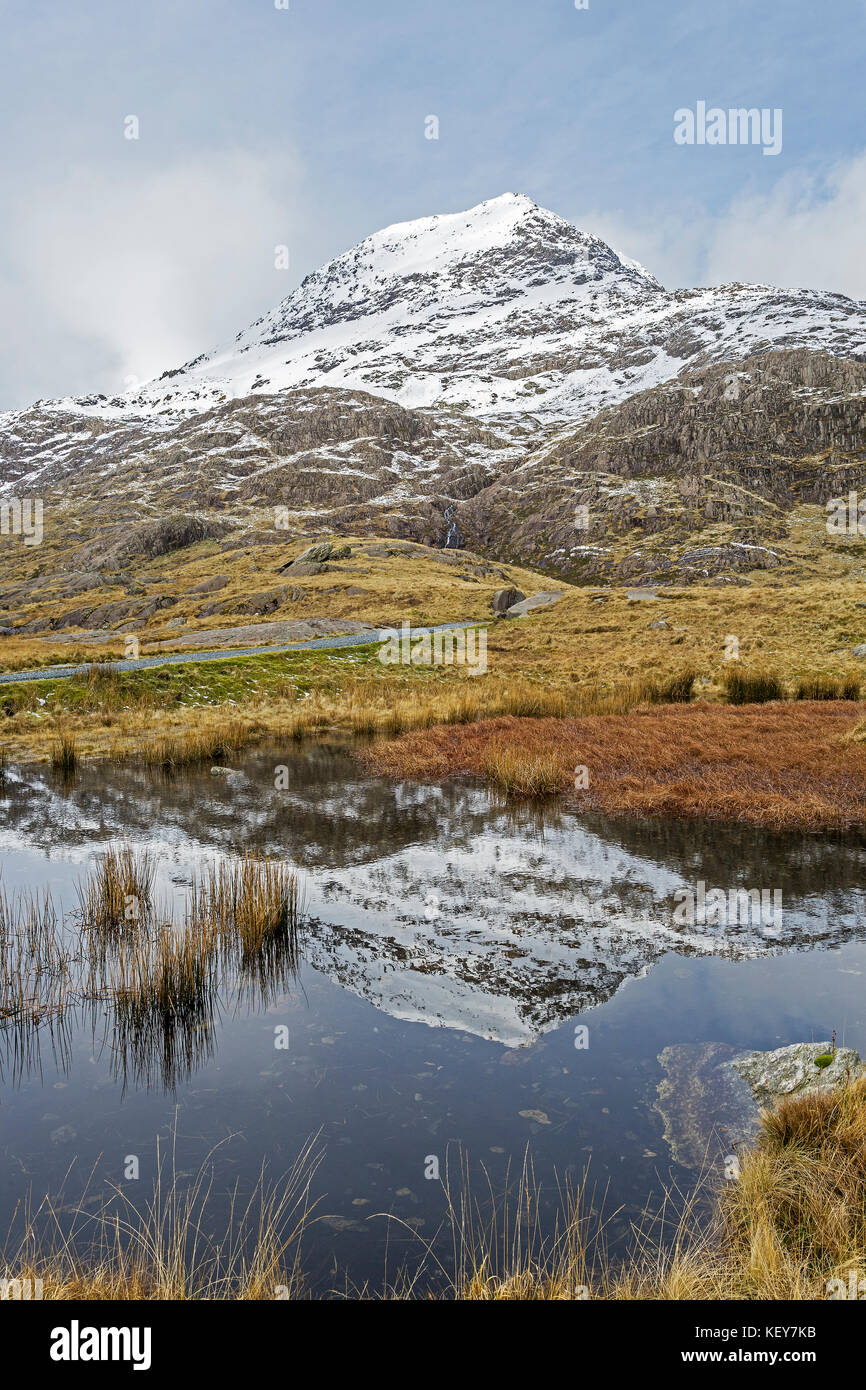 Krippe Goch (Rot Ridge) Teil der Snowdon Horseshoe im Schnee in einem Pool neben der Bergleute Track Snowdonia National Park in Nordwales wider abgedeckt Stockfoto