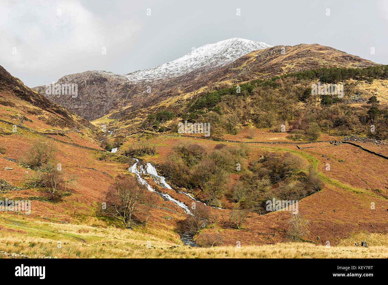 Wasserfälle auf Afon (Fluss) Cwm Llançà aus dem Watkin Weg zum Mount Snowdon gesehen mit Y Llwedd abgedeckt im Schnee Snowdonia National Park North Wales UK Stockfoto