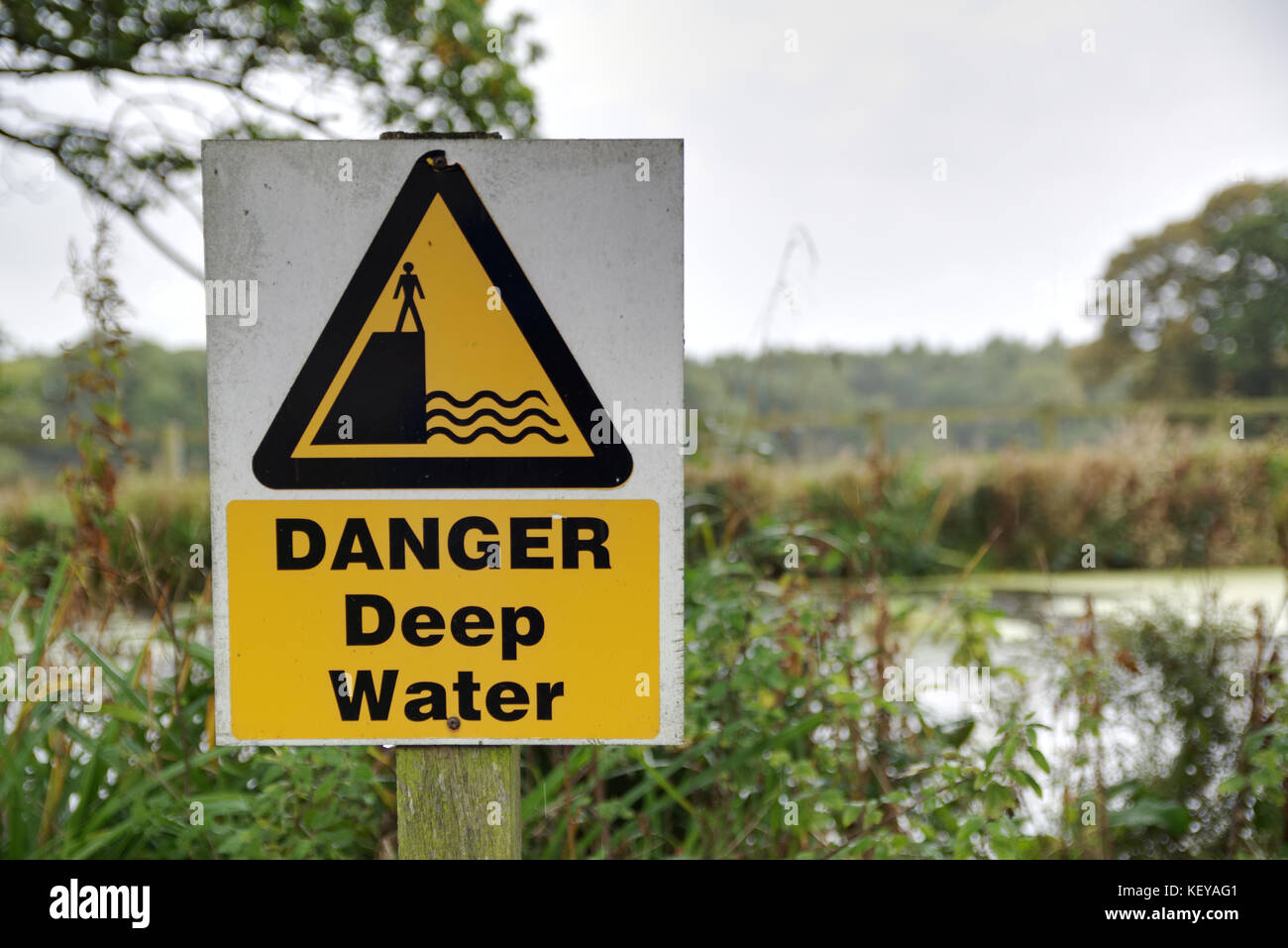 Alte gelbe und schwarze GEFAHR Tiefwasser Schild am See Stockfoto